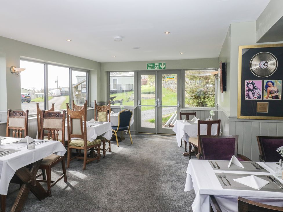 A dining room with tables and chairs at Lochwood Platinum Superior at Three Lochs Holiday Park in Newton Stewart