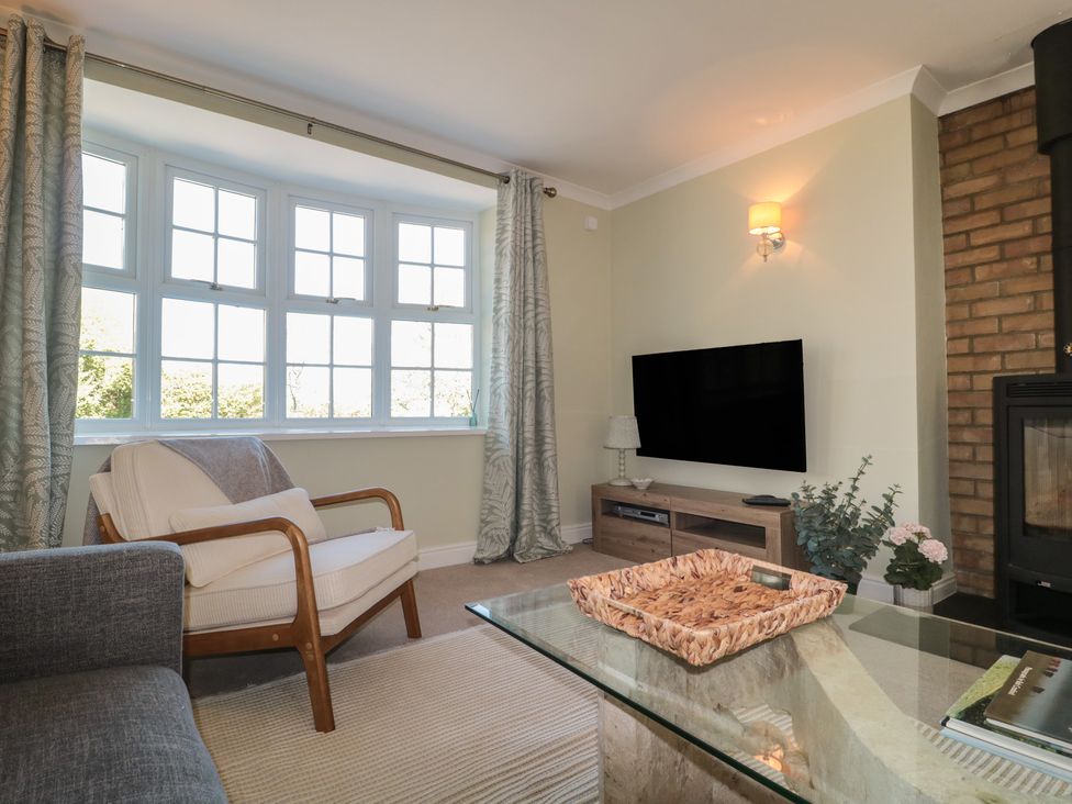 A living room with an armchair and television at The Little Vicarage in Highbridge