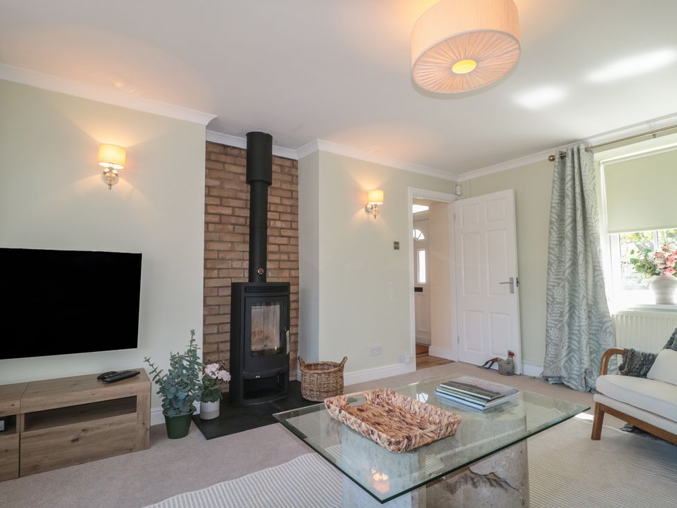 A living room with a fireplace and television at The Little Vicarage in Highbridge