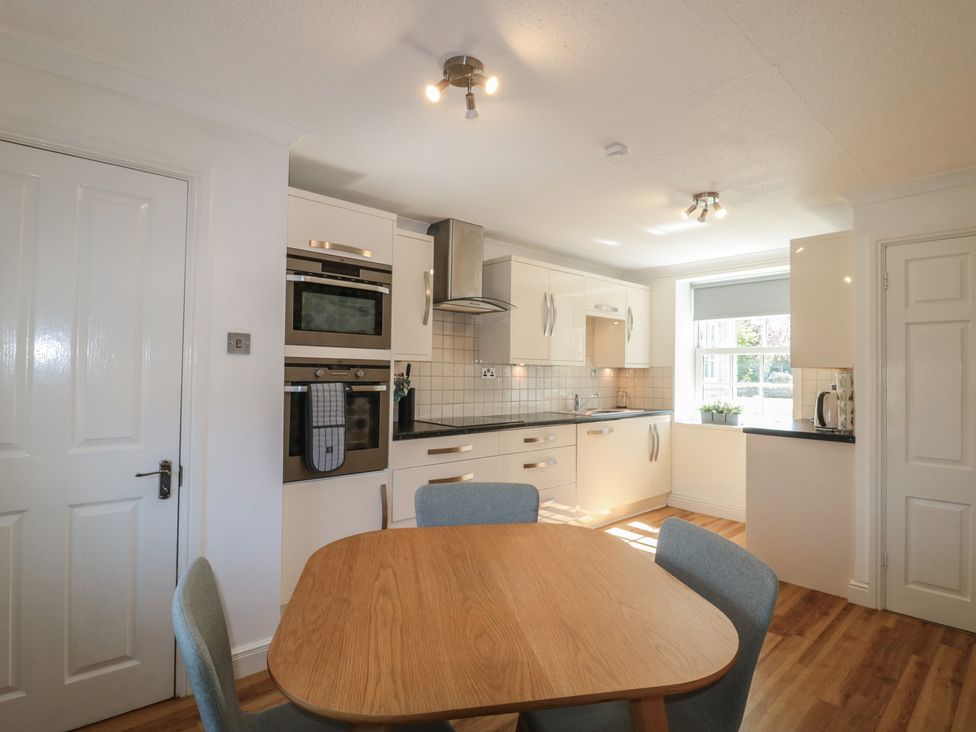 A kitchen with an oven and a table at The Little Vicarage in Highbridge
