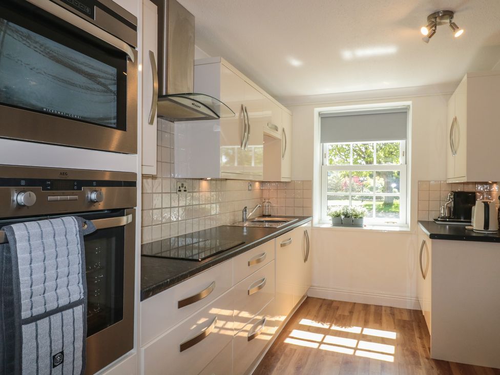 A kitchen with appliances and a window at The Little Vicarage in Highbridge