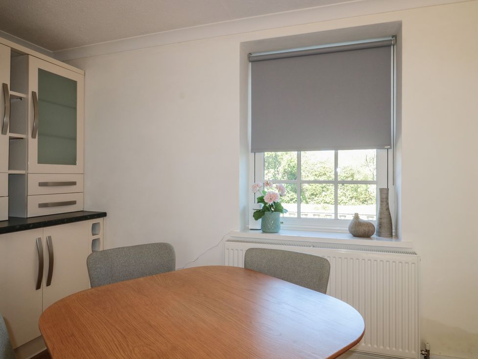 A kitchen with a table, chairs and window at The Little Vicarage in Highbridge