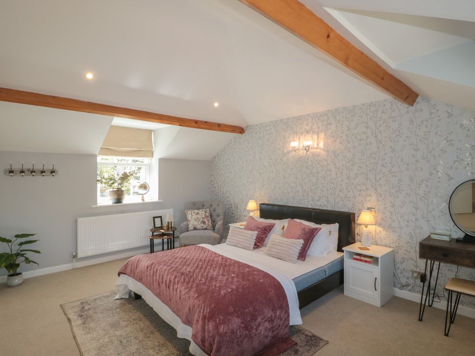 A bedroom with a bed and side table at The Little Vicarage in Highbridge