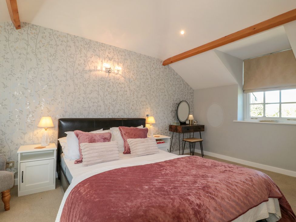 A bedroom with a bed and nightstand at The Little Vicarage in Highbridge