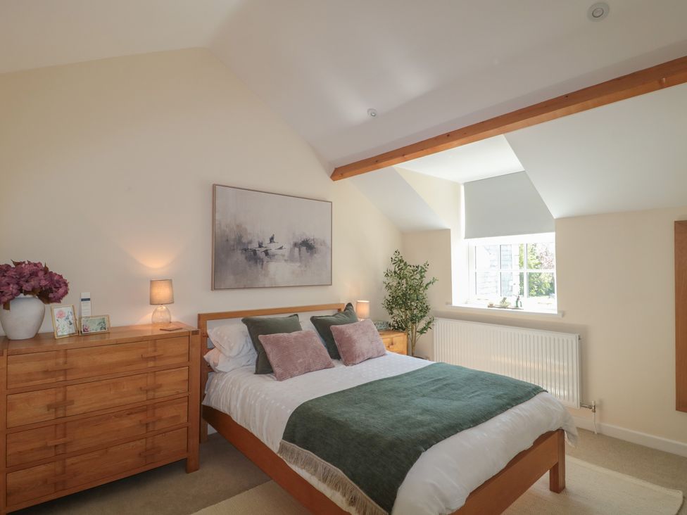A bedroom with a bed and dresser at The Little Vicarage in Highbridge