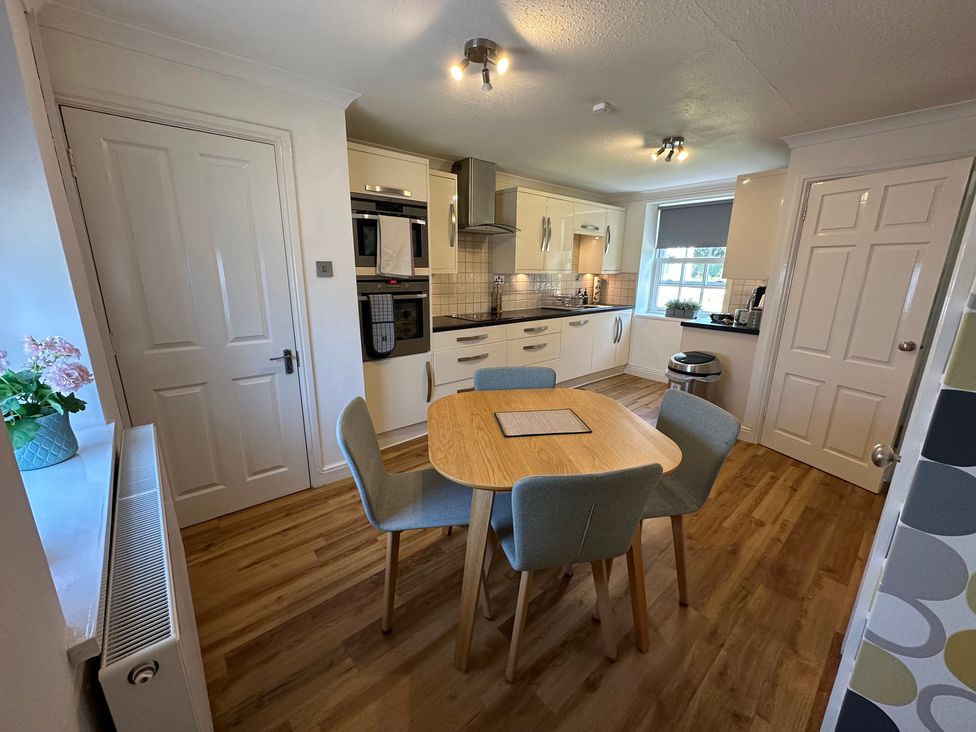 A kitchen with a dining table and chairs at The Little Vicarage in Mark