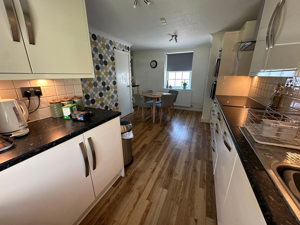A kitchen with counter and dining area at The Little Vicarage in Mark