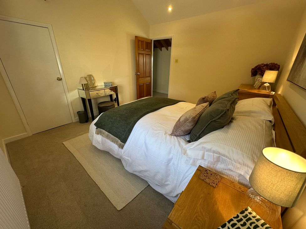 A bedroom with a bed and a nightstand at The Little Vicarage in Mark