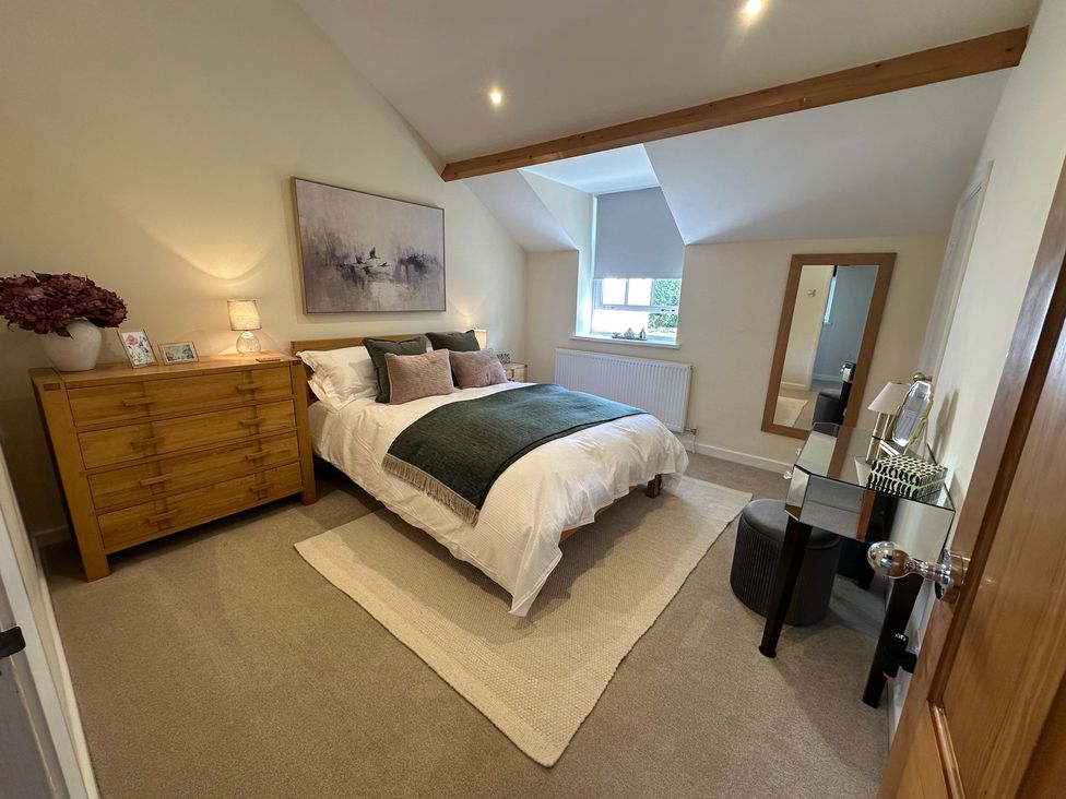 A bedroom with a bed and dresser at The Little Vicarage in Mark