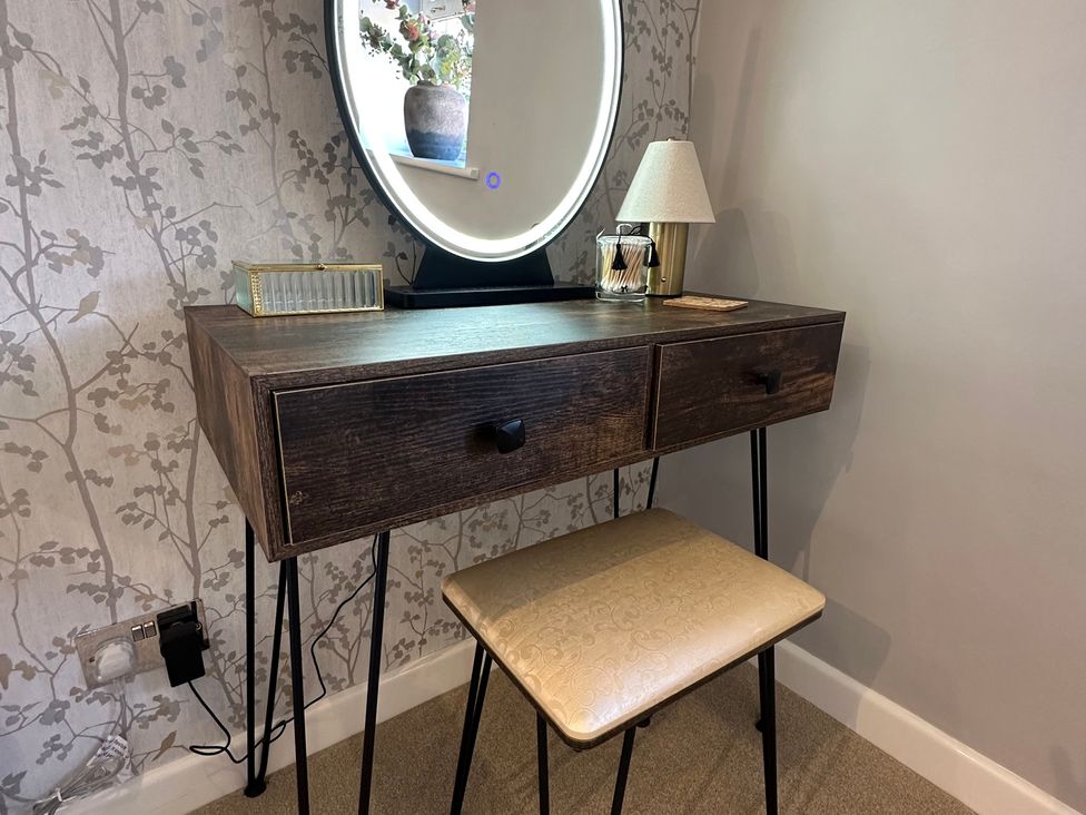 A desk with a mirror and lamp at The Little Vicarage in Mark