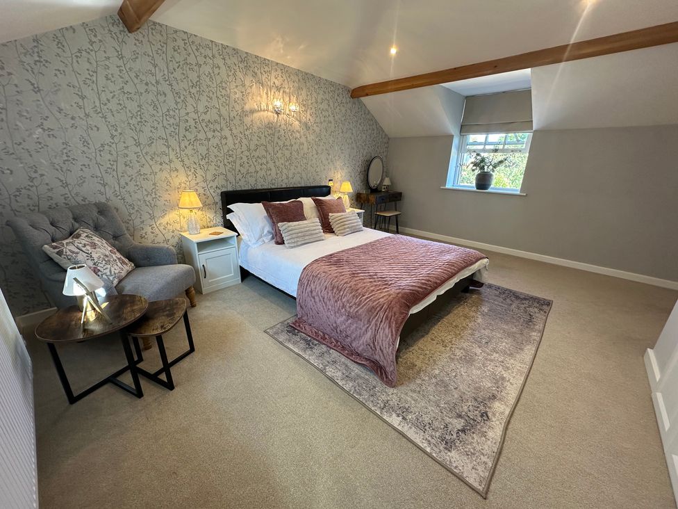 A bedroom with a bed and a chair at The Little Vicarage in Mark