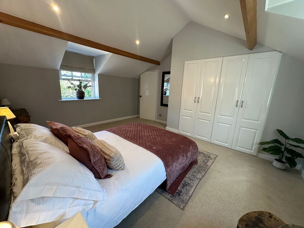 A bedroom with a bed and wardrobe at The Little Vicarage in Mark