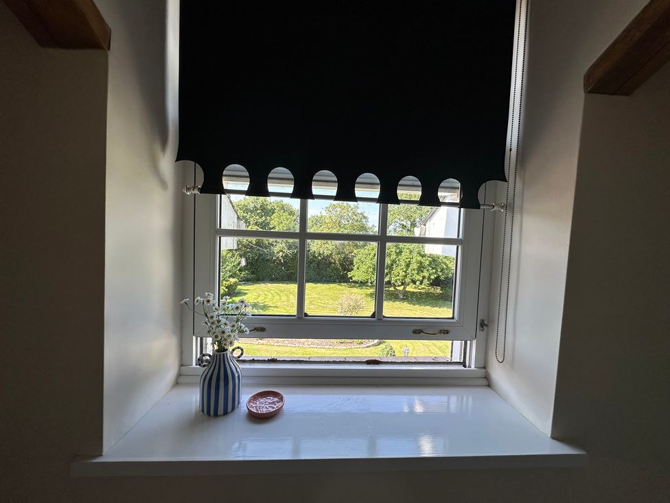 A window with a vase of flowers and a saucer at The Little Vicarage in Mark