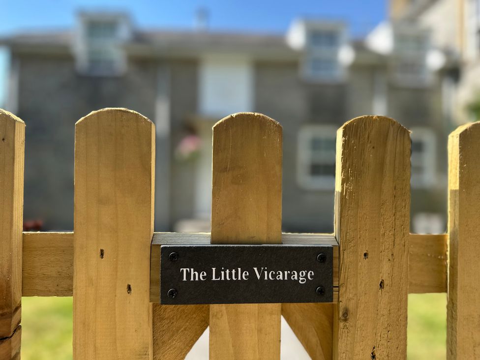 A wooden fence with a sign for The Little Vicarage at The Little Vicarage in Mark