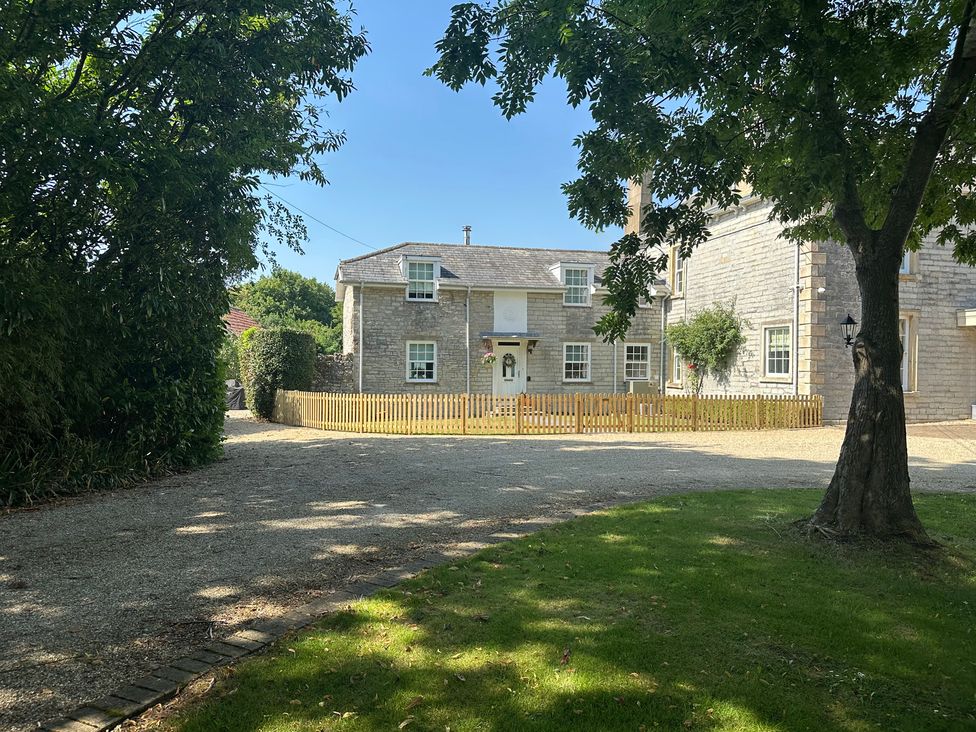 A house with a front fence and trees at The Little Vicarage in Mark