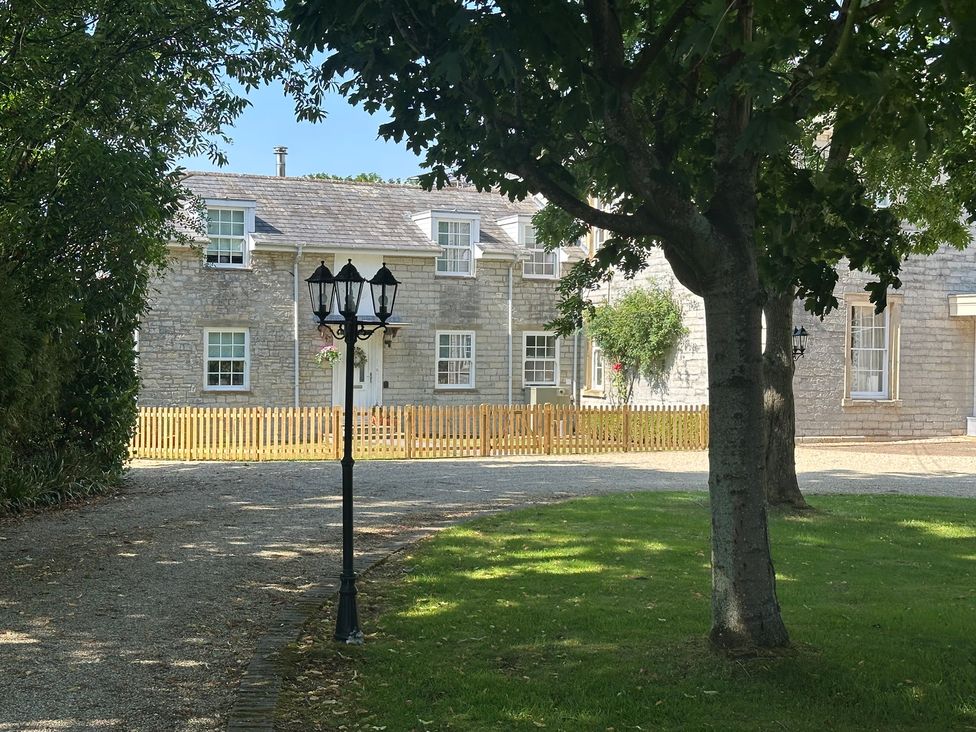 An outdoor view of a house with a fence and lamp post at The Little Vicarage in Mark