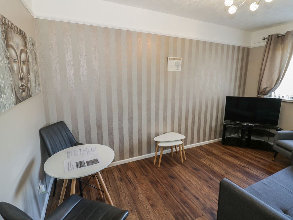 A living room with a television and seating area at 32B Cramp Hill in Darlaston