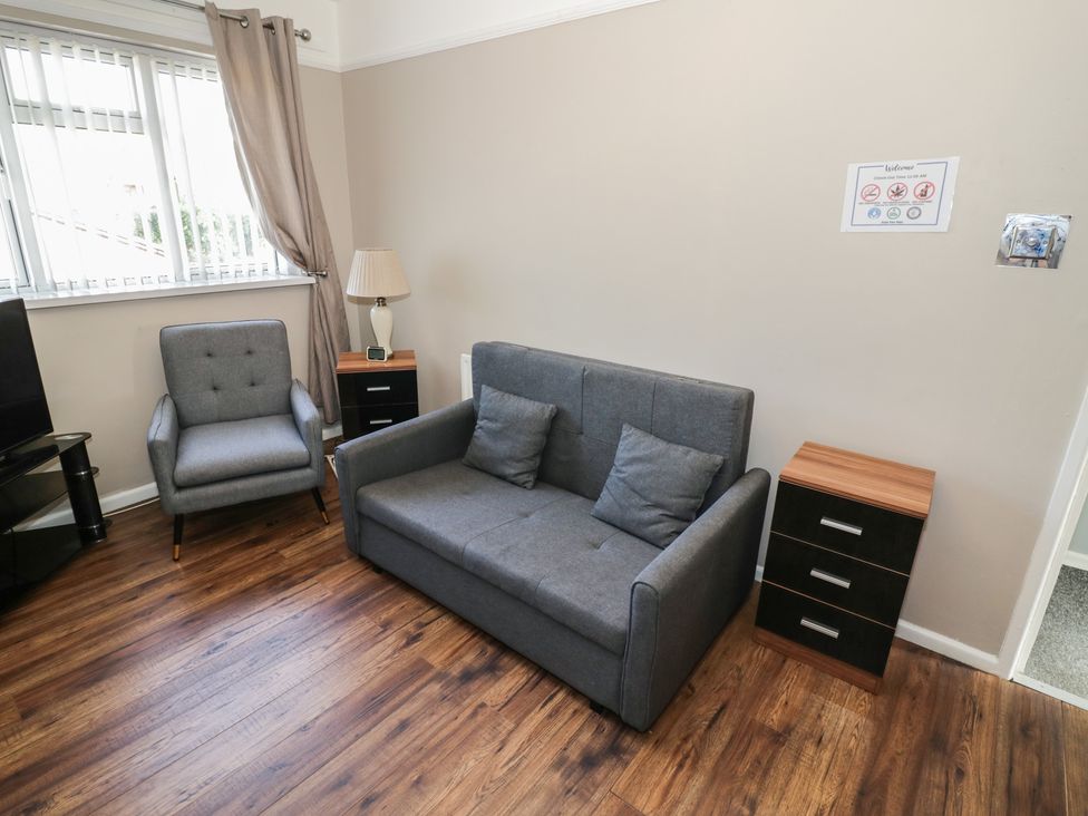 A living room with a sofa and armchair at 32B Cramp Hill in Darlaston