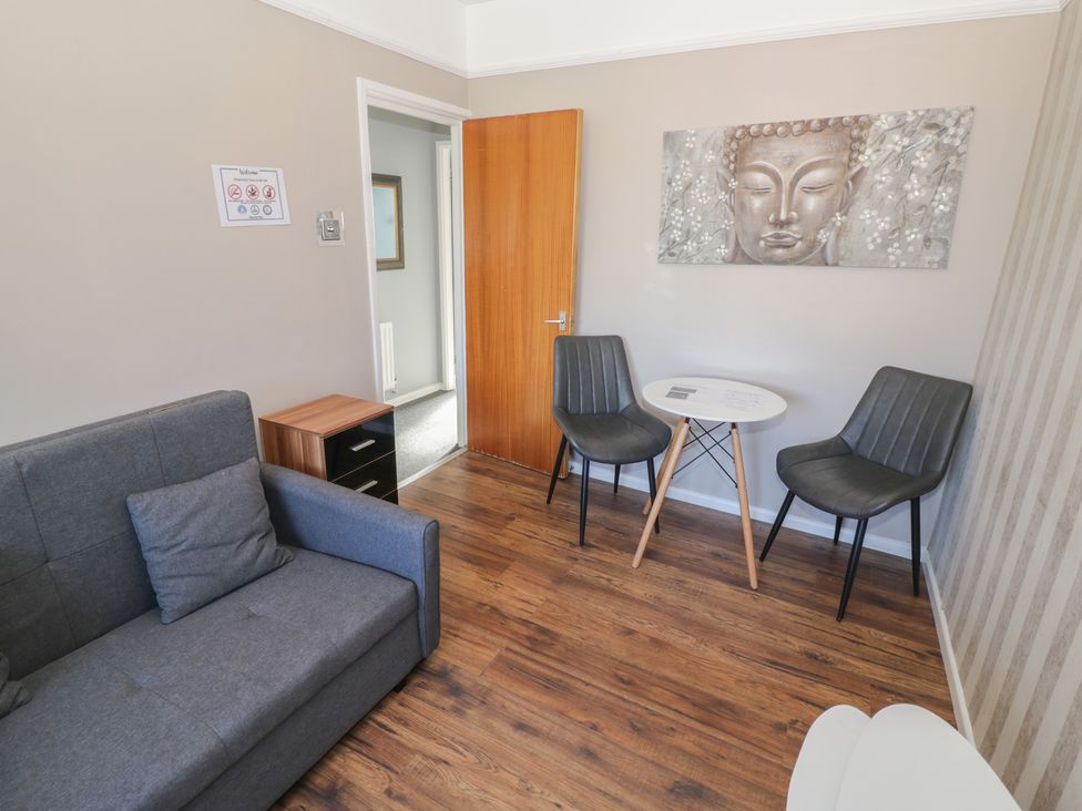 A sitting room with a sofa and table at 32B Cramp Hill in Darlaston