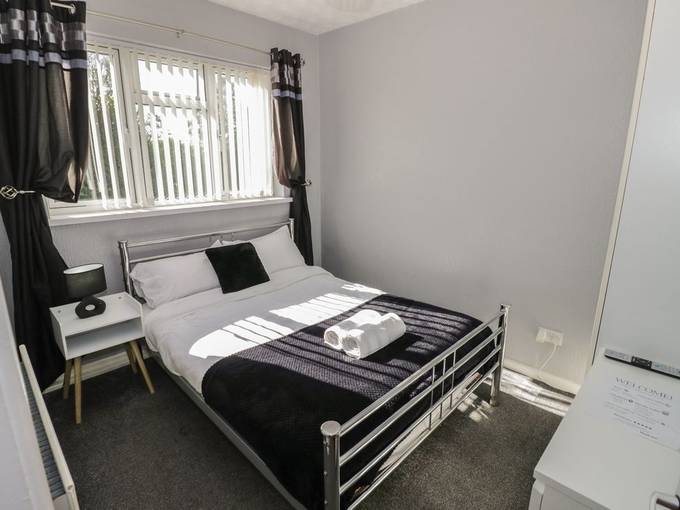 A bedroom with a bed and bedside table at 32B Cramp Hill in Darlaston