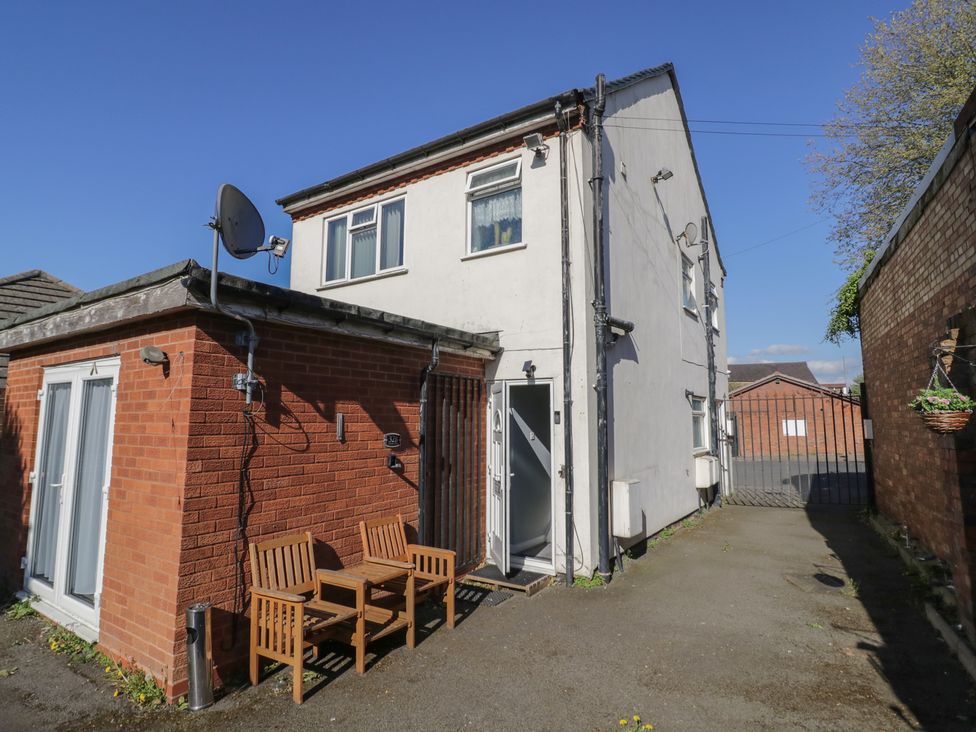 An outdoor view of a house with seating and a satellite dish at 32B Cramp Hill Darlaston