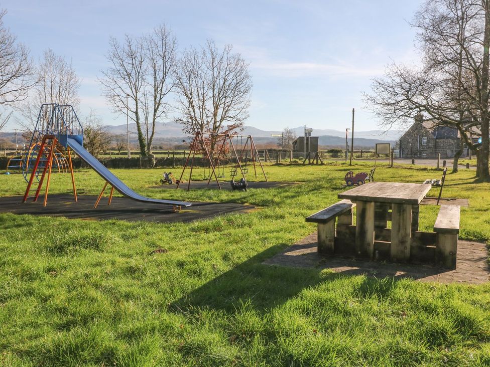 A playground with a slide, swing set, and a picnic table at 2 Bryn Eglwys in Prenteg