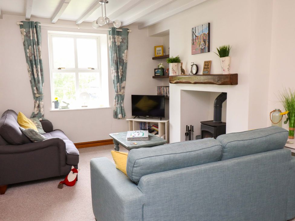 A living room with sofas and television at 2 Bryn Eglwys in Prenteg