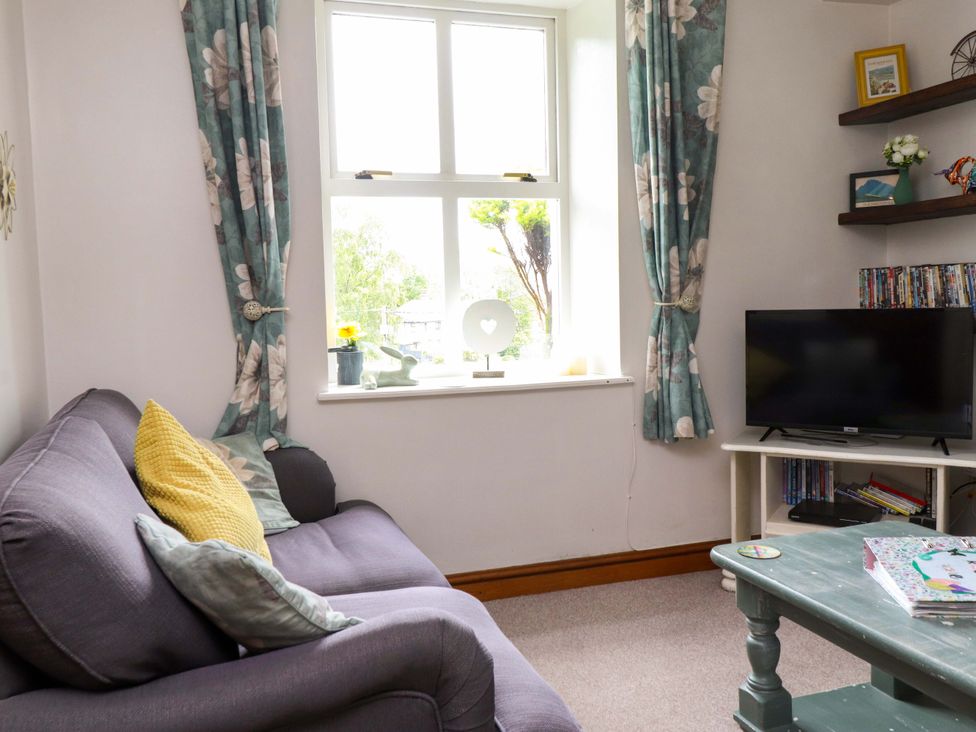 A living room with a sofa and television at 2 Bryn Eglwys in Prenteg