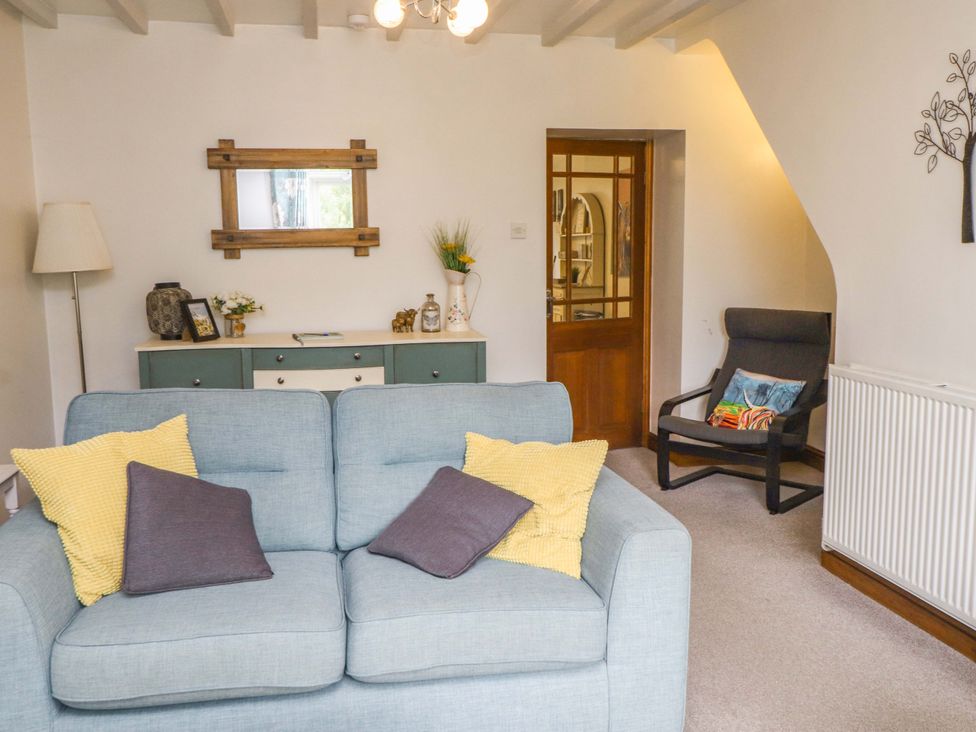 A living room with a sofa and chair at 2 Bryn Eglwys in Prenteg