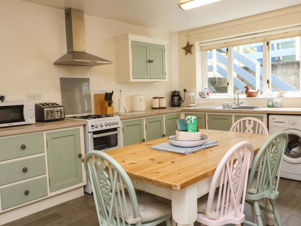 A kitchen with a table and chairs at 2 Bryn Eglwys in Prenteg