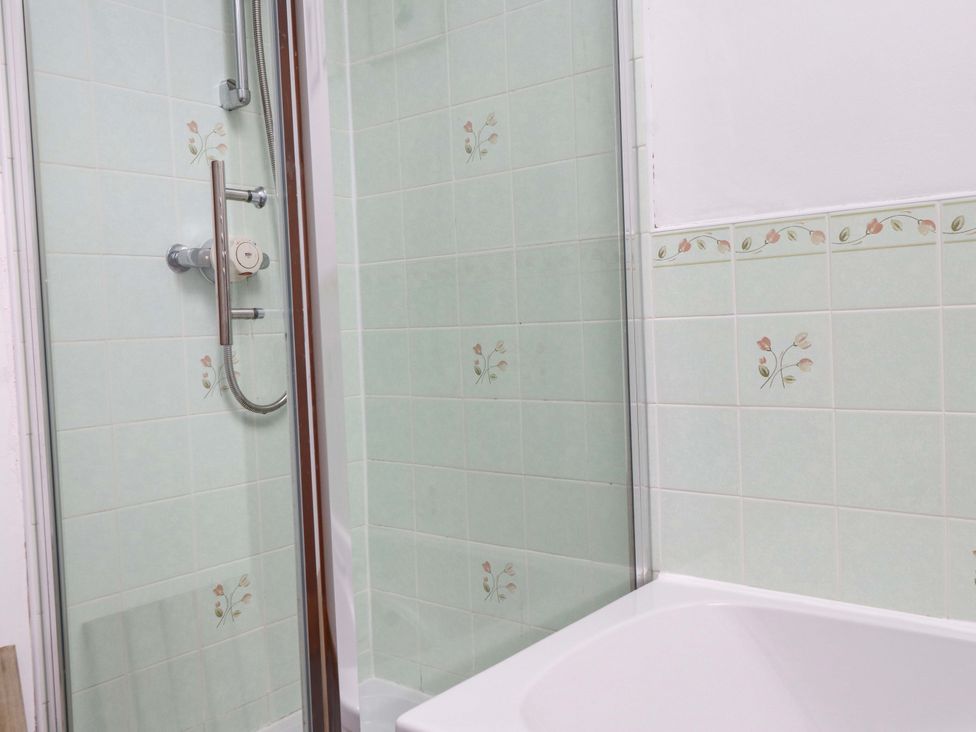 A bathroom with a shower and bathtub at 2 Bryn Eglwys in Prenteg