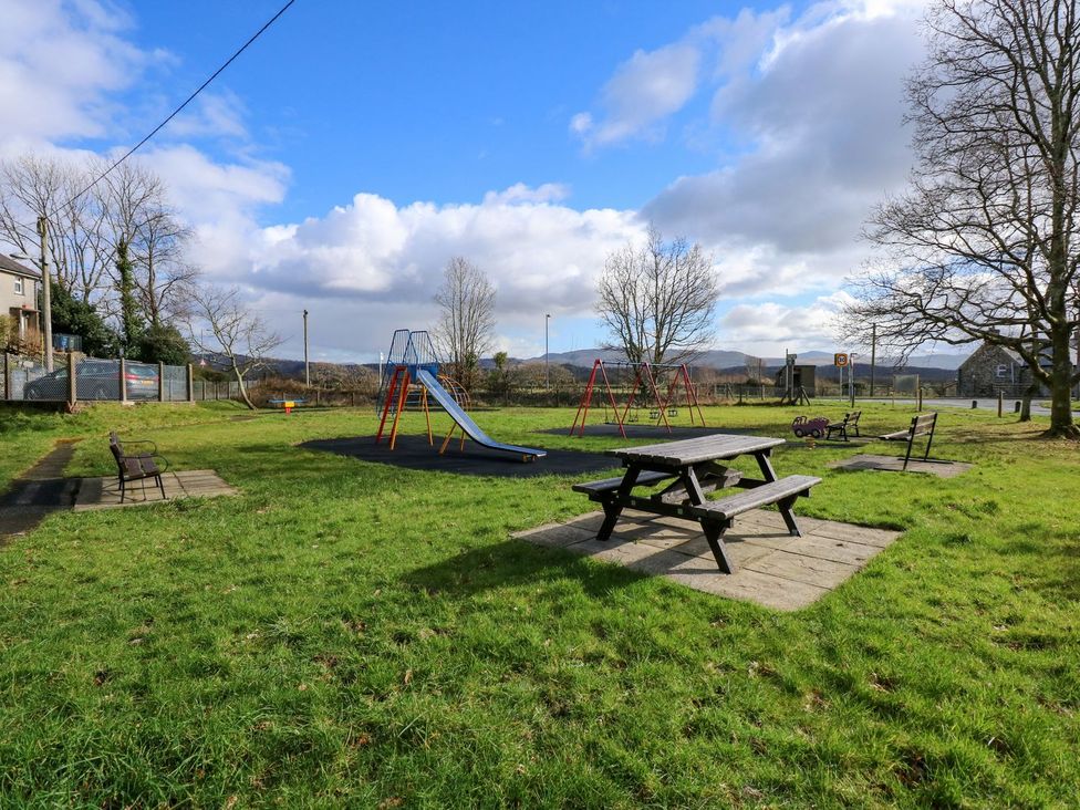 A playground with a slide and swings at 2 Bryn Eglwys, Prenteg near Porthmadog