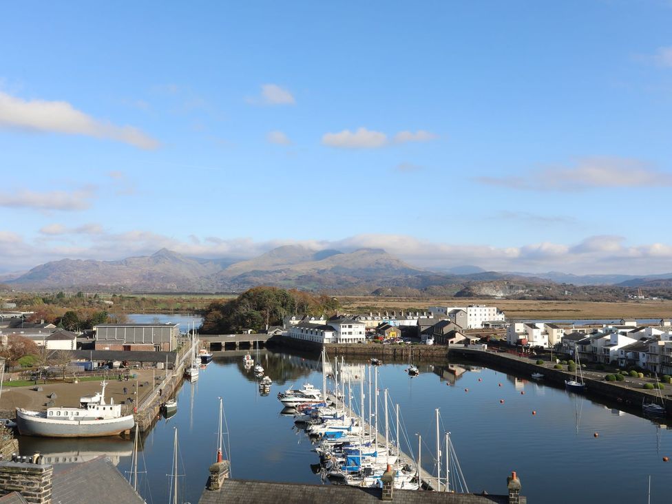 A marina with boats and mountains in the background at 2 Bryn Eglwys in Prenteg near Porthmadog