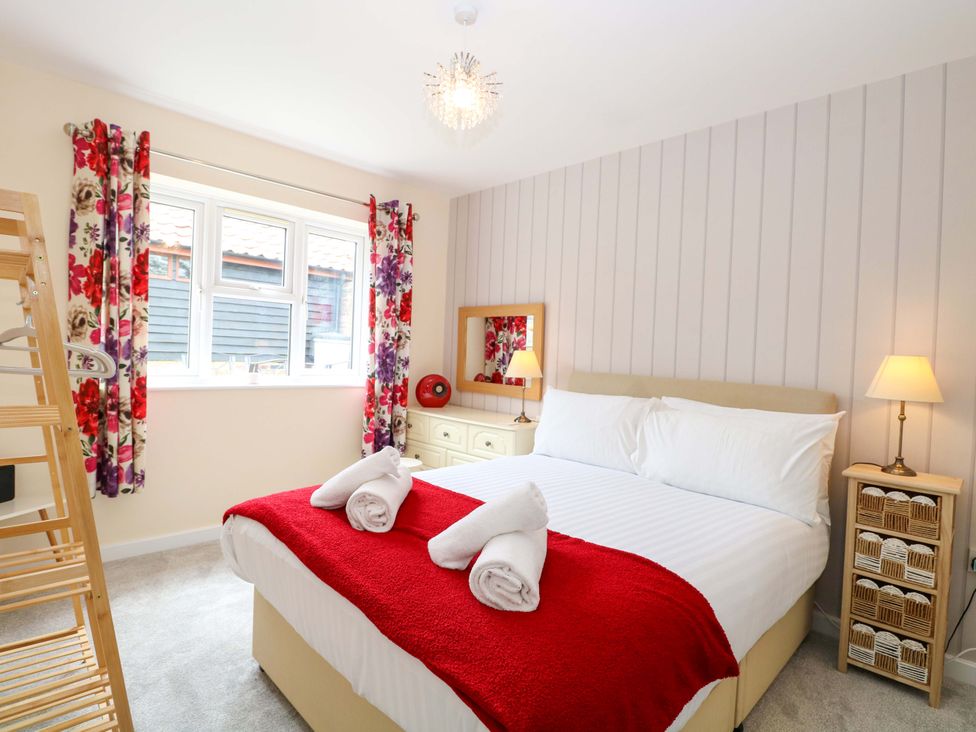 A bedroom with a bed and a dressing table at The Mill House Gardens