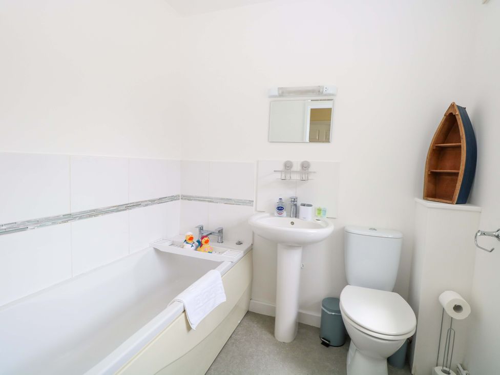 A bathroom with a bathtub, toilet, and wash basin at The Mill House Gardens