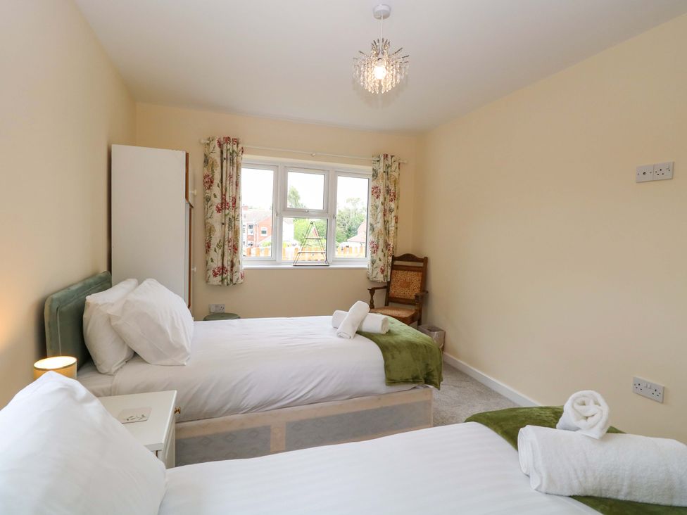 A bedroom with two beds and a wardrobe at The Mill House Gardens 