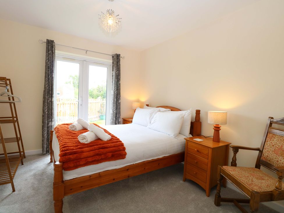 A bedroom with a bed and wardrobe at The Mill House Gardens