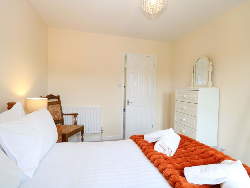 A bedroom with a bed and chair at The Mill House Gardens 