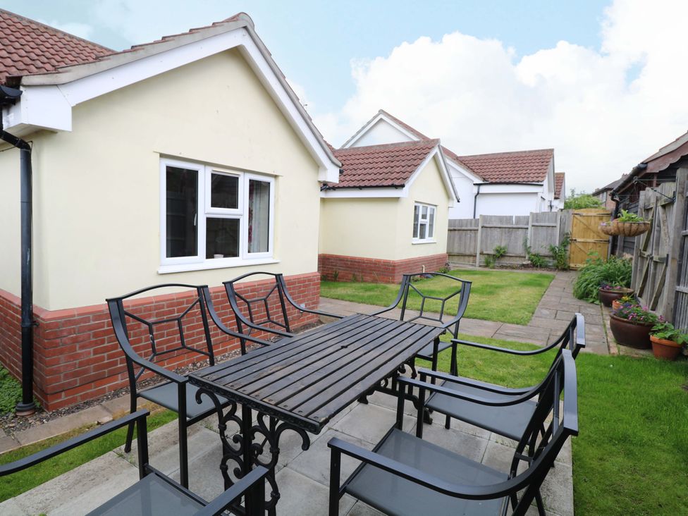 A garden with a table and chairs at The Mill House Gardens 