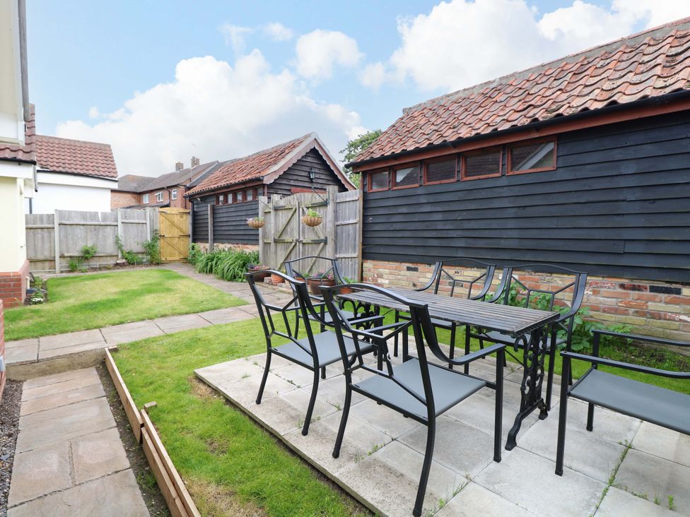 A garden with a table and chairs at The Mill House Gardens