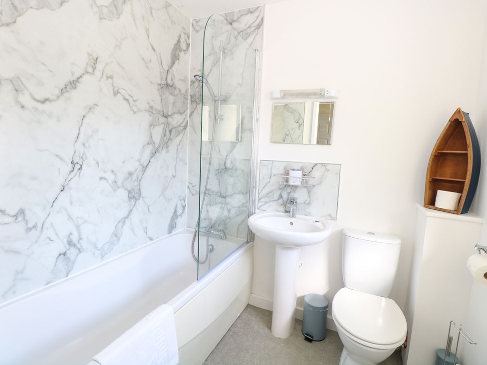 A bathroom with a bathtub and sink at The Mill House Gardens Oulton Broad