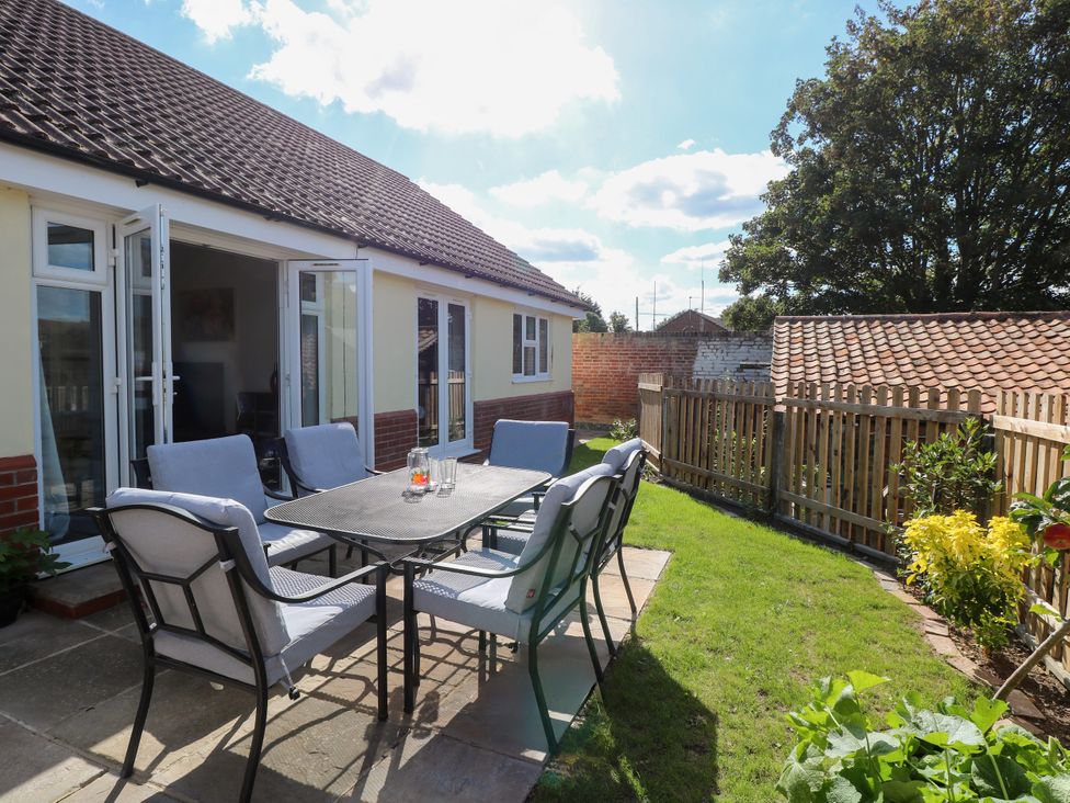 A garden with patio furniture at The Mill House Gardens Oulton Broad