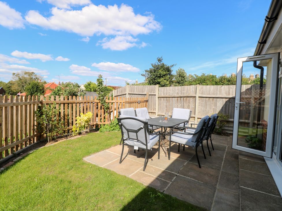 A garden with a table and chairs at The Mill House Gardens Oulton Broad