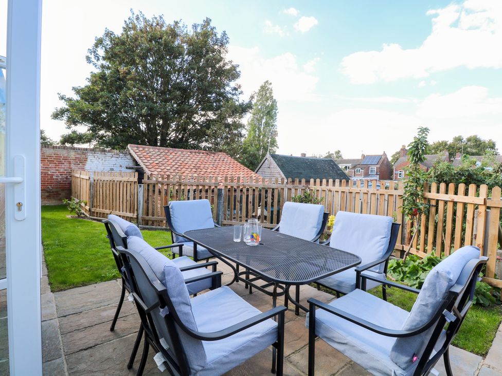 A garden with a table and chairs at The Mill House Gardens Oulton Broad