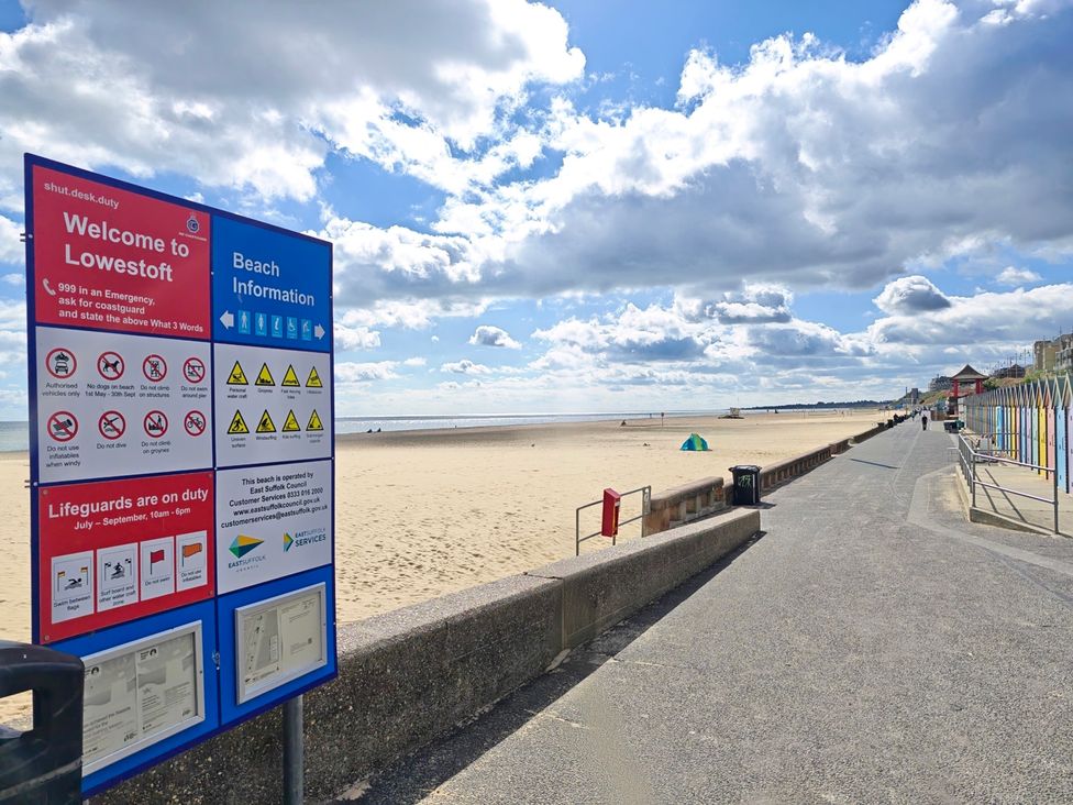 A beach with a sign for information at The Mill House Gardens Oulton Broad