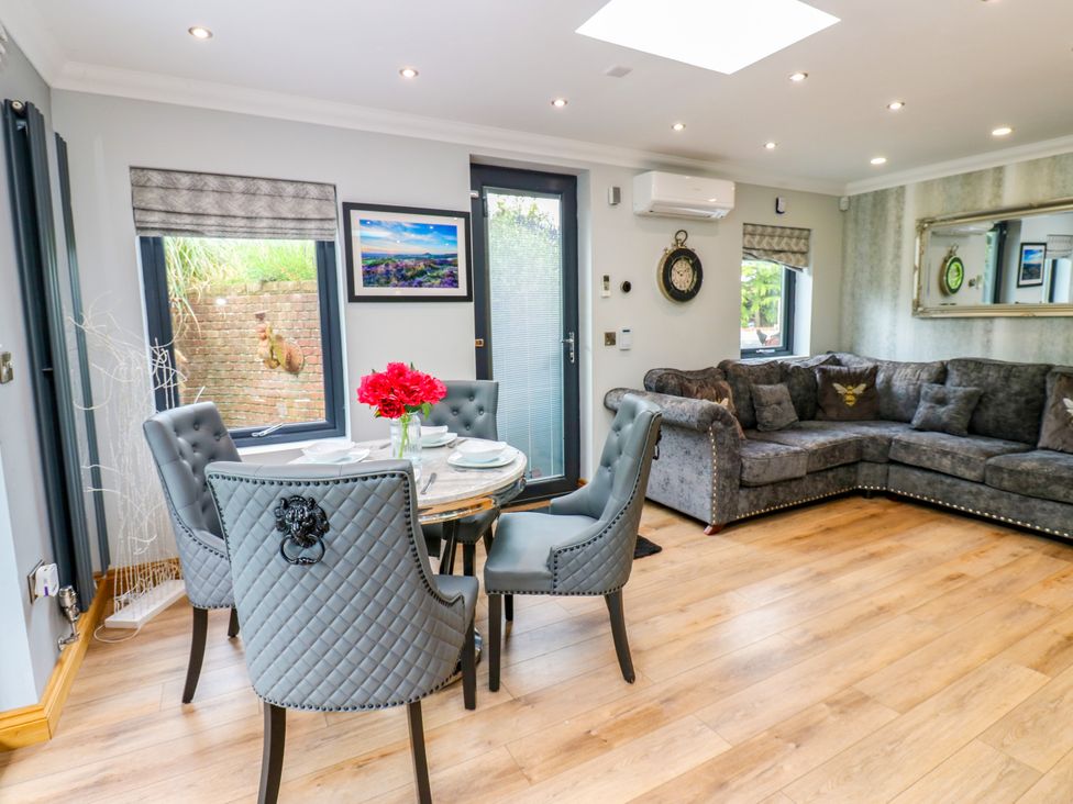 A dining area with a round table and chairs at Caesars Lodge in Houghton Bank near Heighington