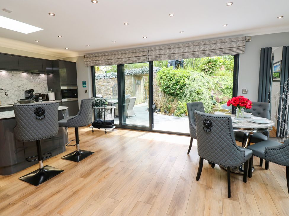 A kitchen area with a dining table and sliding doors leading to a garden at Caesars Lodge in Houghton Bank near Heighington