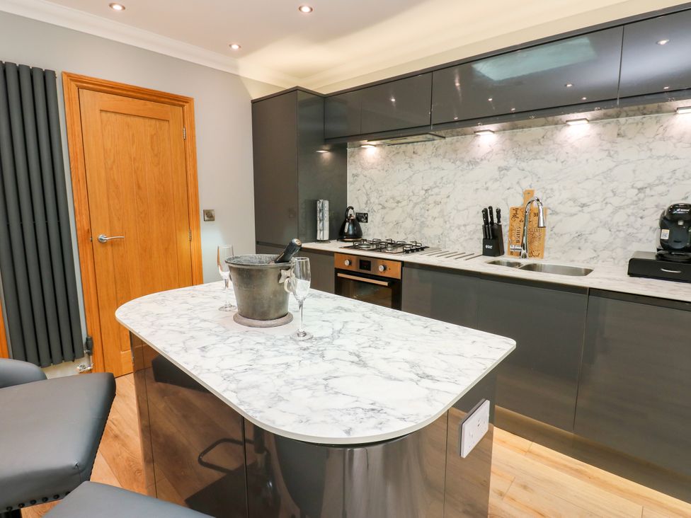 A kitchen with a marble counter and bar stools at Caesars Lodge in Houghton Bank near Heighington