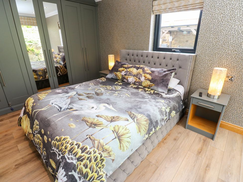 A bedroom with a bed and bedside table at Caesars Lodge Houghton Bank near Heighington