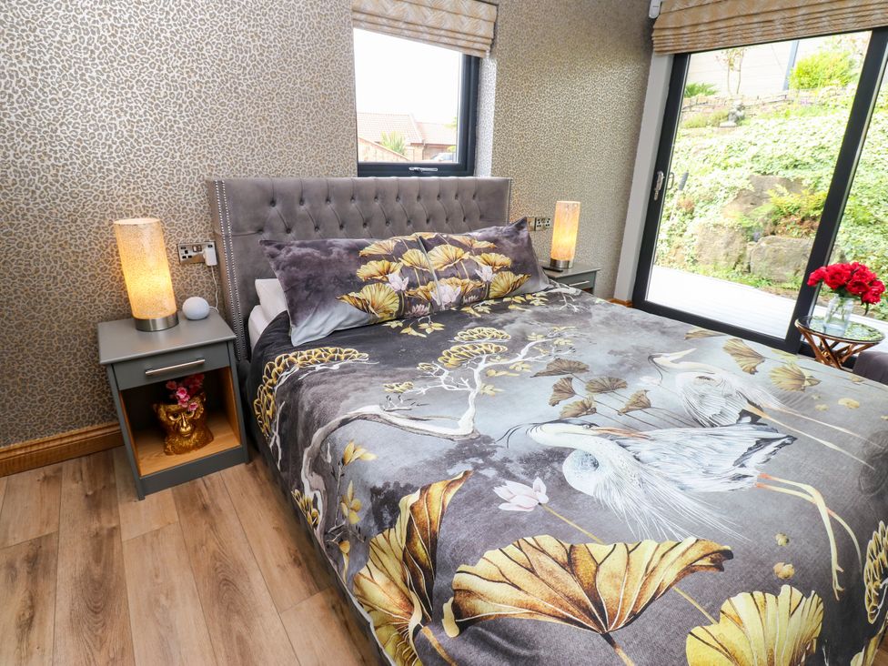 A bedroom with a bed and bedside table at Caesars Lodge in Houghton Bank near Heighington